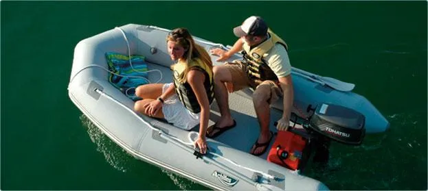 Slide: The Image of 2024 Achilles LEX-88 inflatable boat with two people on a lake. - 2