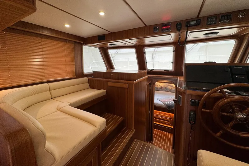 Slide: The Image of Luxurious interior of 2026 Helmsman Trawlers 38 Sedan with wood finish and plush seating. - 13