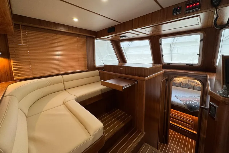 Slide: The Image of Luxurious interior of 2026 Helmsman Trawlers 38 Sedan with elegant wood finish and cozy seating. - 14