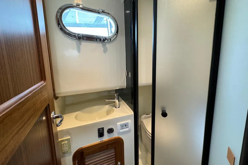 Slide: The Image of Bathroom interior of 2026 Helmsman Trawlers 38 Sedan with sink and porthole window. - 16