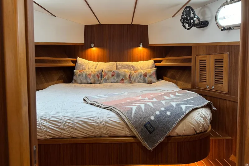 Slide: The Image of 2026 Helmsman Trawlers 38 Sedan cabin with cozy bed and wooden interior design. - 19
