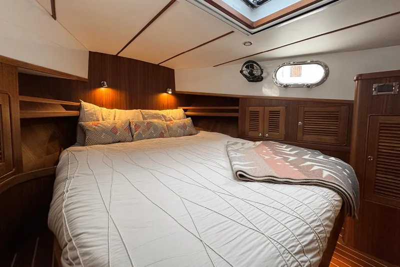 Slide: The Image of Cozy cabin interior of 2026 Helmsman Trawlers 38 Sedan with wood paneling and skylight. - 20