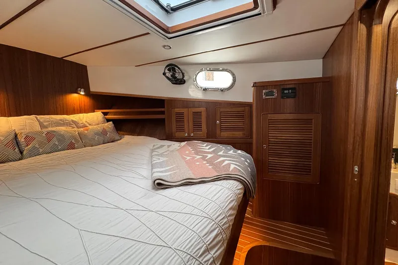 Slide: The Image of Luxurious cabin interior of 2026 Helmsman Trawlers 38 Sedan with wood finish and cozy bedding. - 21