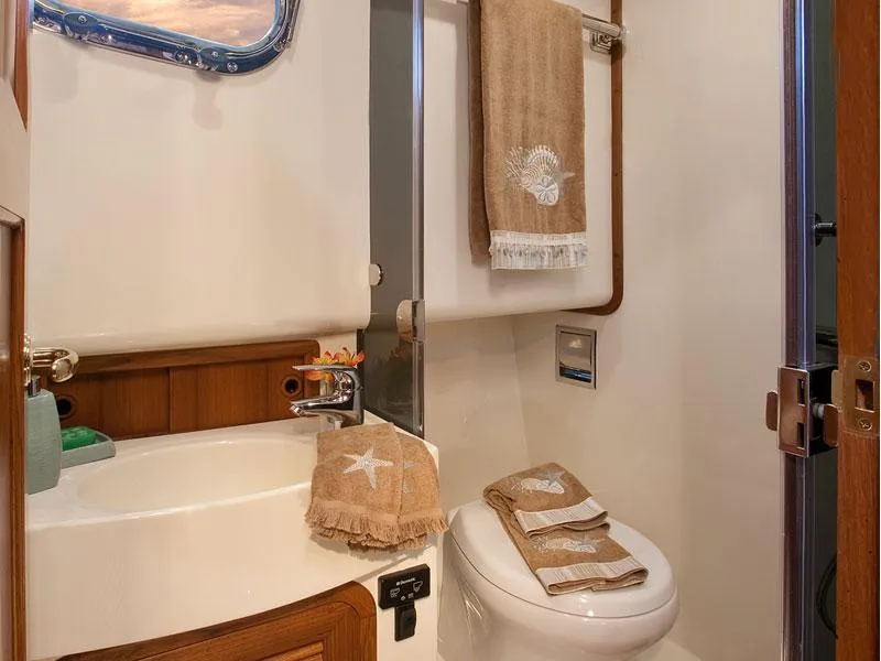 Slide: The Image of Bathroom interior of 2026 Helmsman Trawlers 38 Sedan, featuring sink and toilet with nautical decor. - 35