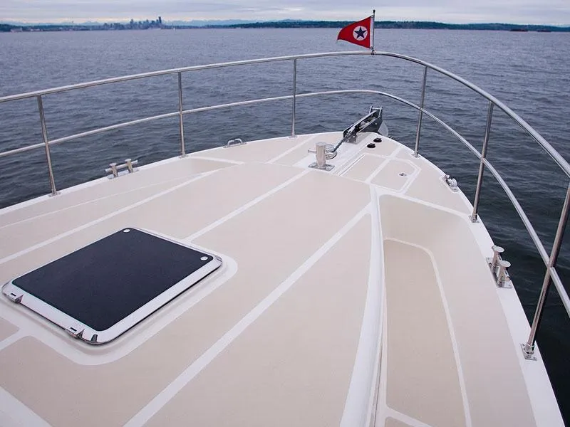 Slide: The Image of Helmsman Trawlers 38 Sedan 2026 yacht deck with railing and flag on open water. - 45