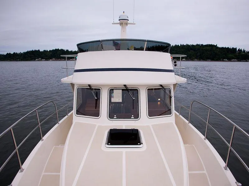 Slide: The Image of 2026 Helmsman Trawlers 38 Sedan on calm water, showcasing sleek design and spacious deck. - 46