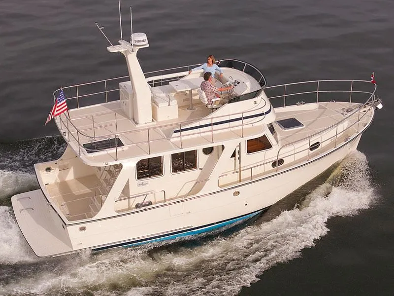 Slide: The Image of 2026 Helmsman Trawlers 38 Sedan cruising on water, featuring spacious deck and modern design. - 48