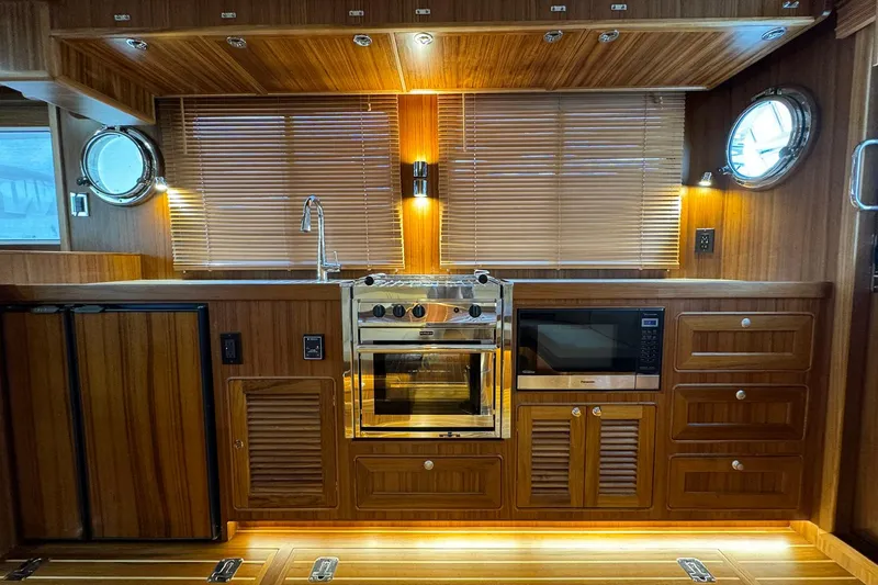 Slide: The Image of Luxurious kitchen interior of 2026 Helmsman Trawlers 38 Sedan with wood finish and modern appliances. - 9