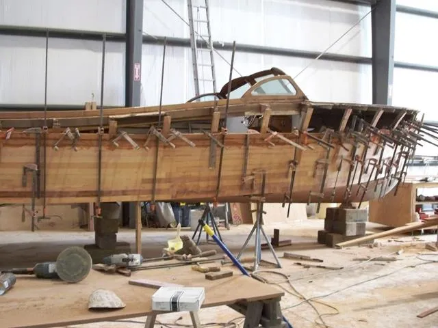Slide: The Image of 1956 Emancipator cruiser under restoration in a workshop with clamps and tools. - 12