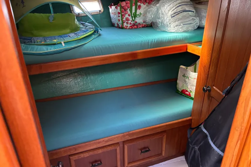 Slide: The Image of 1985 Egg Harbor 37 Tournament cabin with wooden bunk beds and storage. - 13