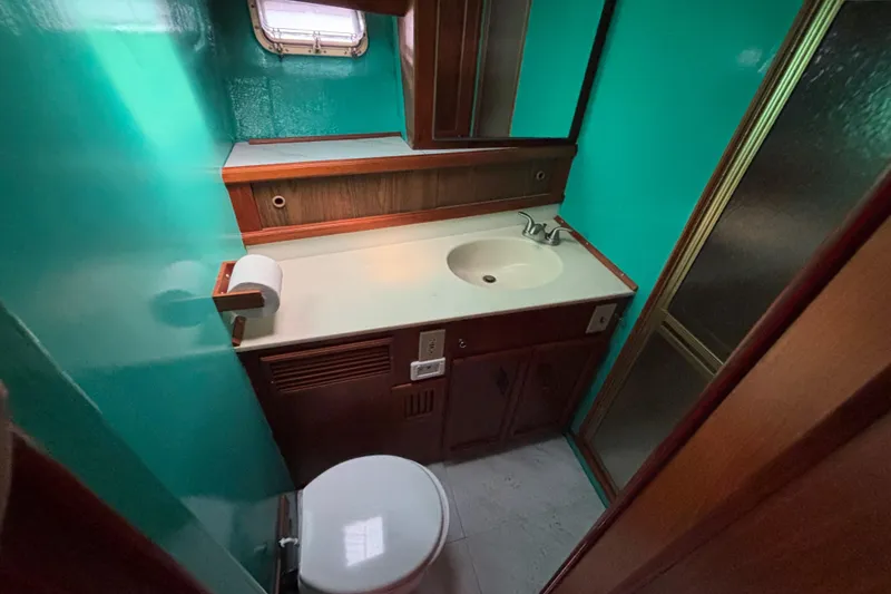 Slide: The Image of Bathroom interior of 1985 Egg Harbor 37 Tournament yacht with teal walls and wood accents. - 15