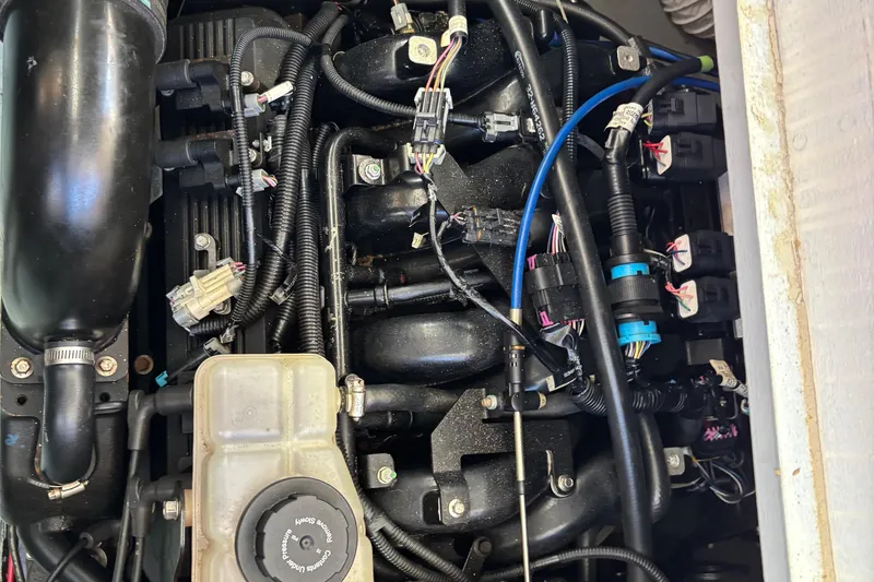 Slide: The Image of Engine components of a 1985 Egg Harbor 37 Tournament boat, featuring wiring and hoses. - 24