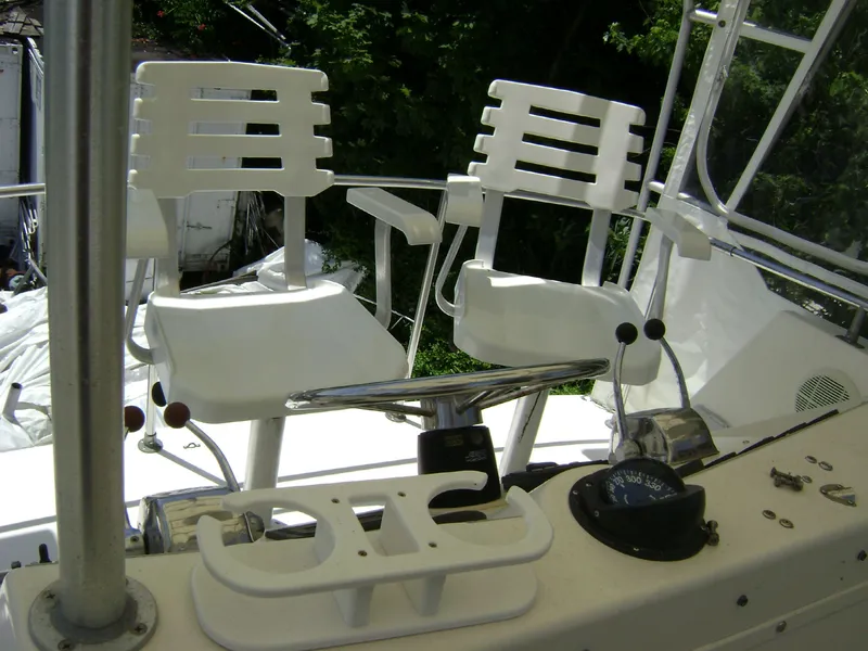 Slide: The Image of 1985 Egg Harbor 37 Tournament boat cockpit with white chairs and steering controls. - 4