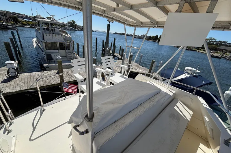 Slide: The Image of 1985 Egg Harbor 37 Tournament yacht docked at marina, featuring spacious deck and seating. - 9