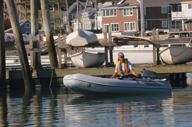 Slide: The Image of Person operating 2024 Achilles LSI-290E inflatable boat near dock. - 3