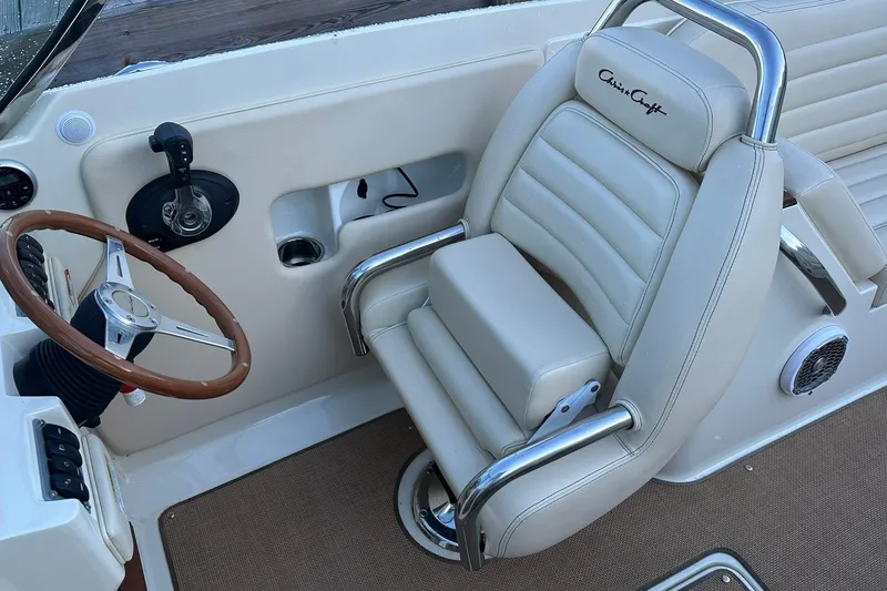Slide: The Image of 2013 Chris-Craft Corsair 25 boat interior with steering wheel and luxurious seating. - 15