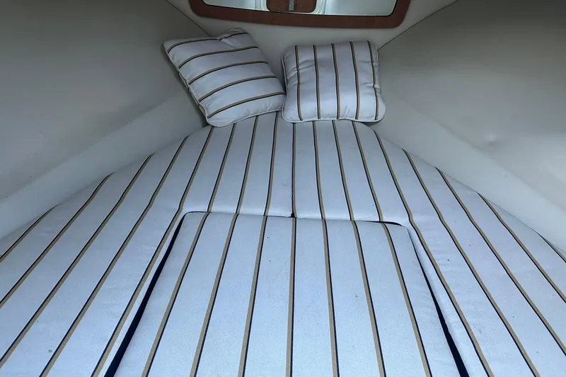 Slide: The Image of 2013 Chris-Craft Corsair 25 cabin interior with striped cushions and pillows. - 21