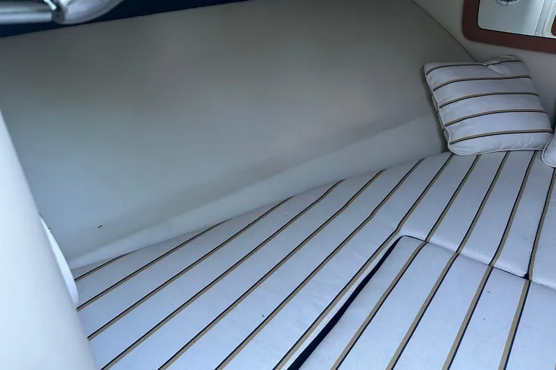Slide: The Image of 2013 Chris-Craft Corsair 25 cabin interior with striped cushions and pillows. - 22