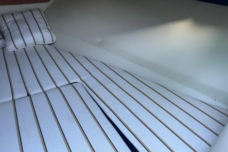 Slide: The Image of 2013 Chris-Craft Corsair 25 cabin interior with striped cushions and pillow. - 23