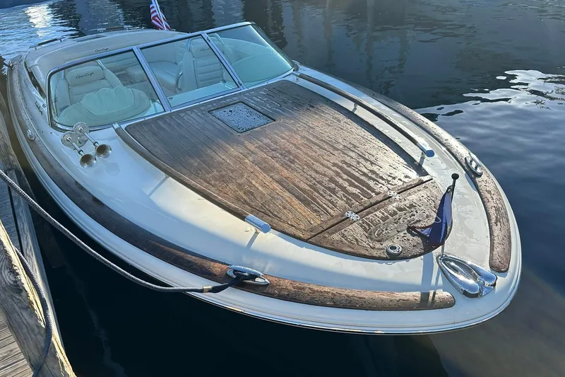 Slide: The Image of 2013 Chris-Craft Corsair 25 boat with wooden deck, docked on calm water. - 5