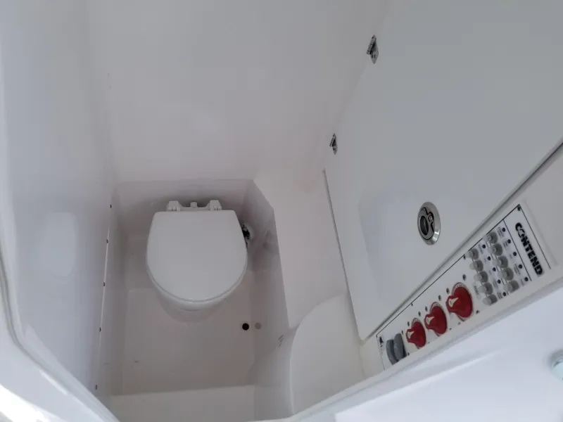 Slide: The Image of 2024 Contender 25 Tournament boat bathroom with toilet and control panel. - 13
