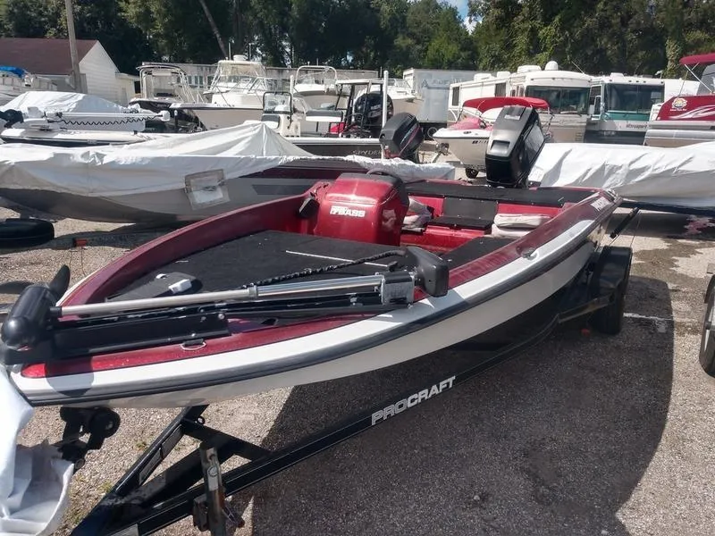 Slide: The Image of 1998 ProCraft 17 Bass boat in a marina, red and white, on a trailer. - 3