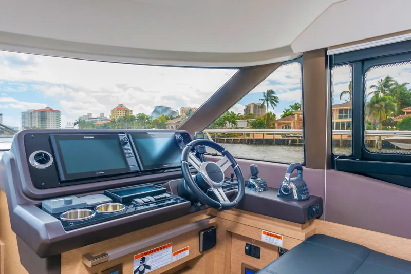 Slide: The Image of Prestige 460 Flybridge 2025 yacht helm station with modern navigation systems and waterfront view. - 22