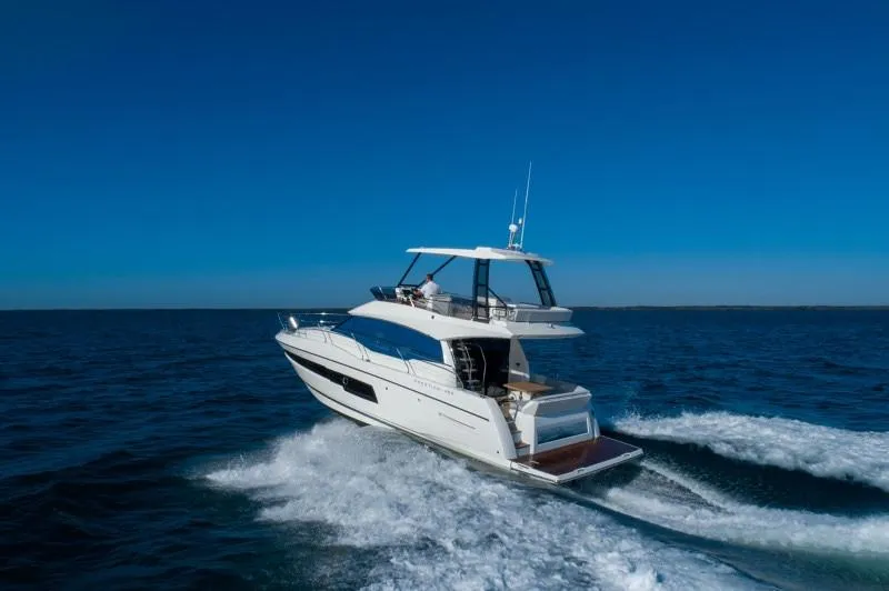 Slide: The Image of 2025 Prestige 460 Flybridge yacht cruising on open water. - 30
