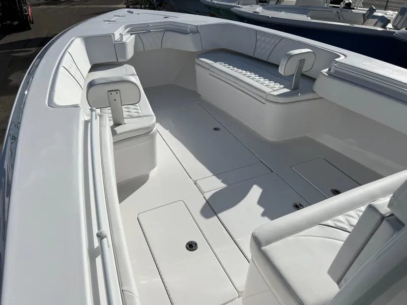 Slide: The Image of 2024 Contender 32 ST boat interior with white seating and storage compartments. - 11