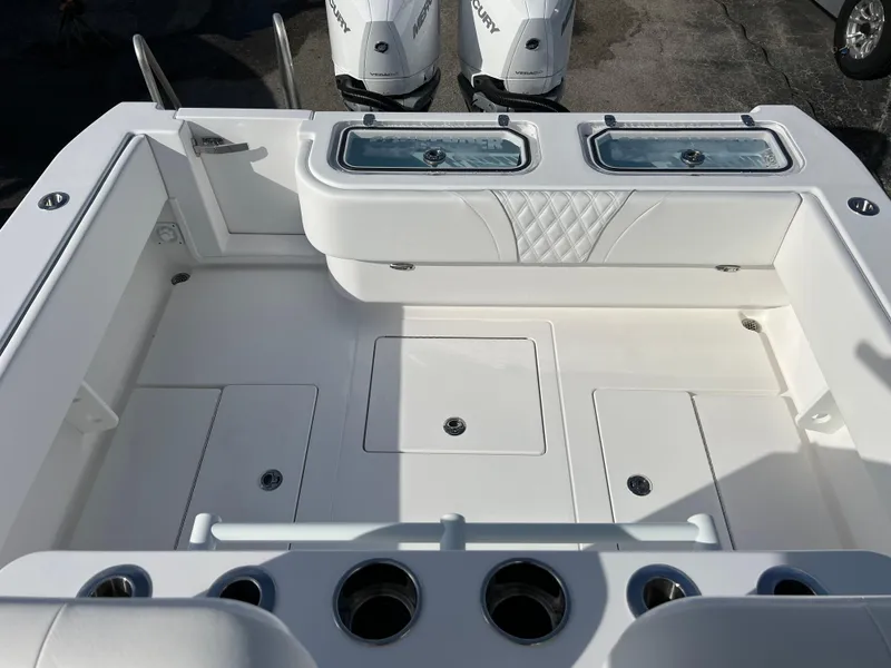Slide: The Image of 2024 Contender 32 ST boat deck with storage compartments and twin outboard engines. - 17