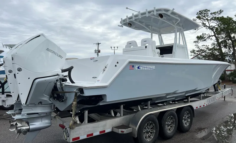 Slide: The Image of 2024 Contender 32 ST boat on a trailer with Mercury outboard engines. - 4