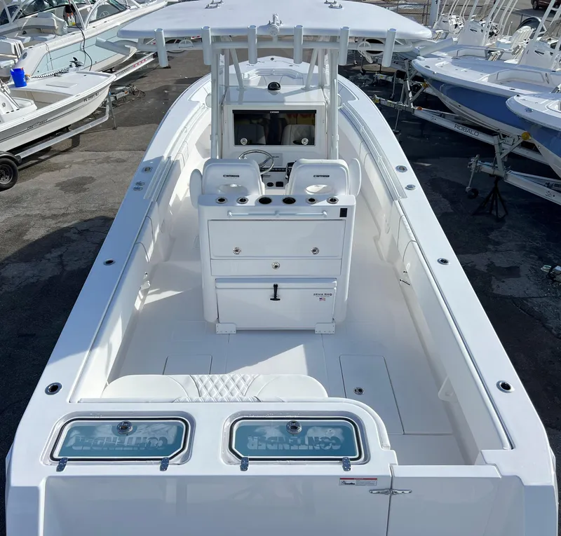 Slide: The Image of 2024 Contender 32 ST boat with center console and dual seats, docked among other boats. - 6