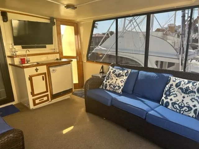 Slide: The Image of Interior of 1989 Californian 48 Motor Yacht with blue sofa and kitchenette. - 11