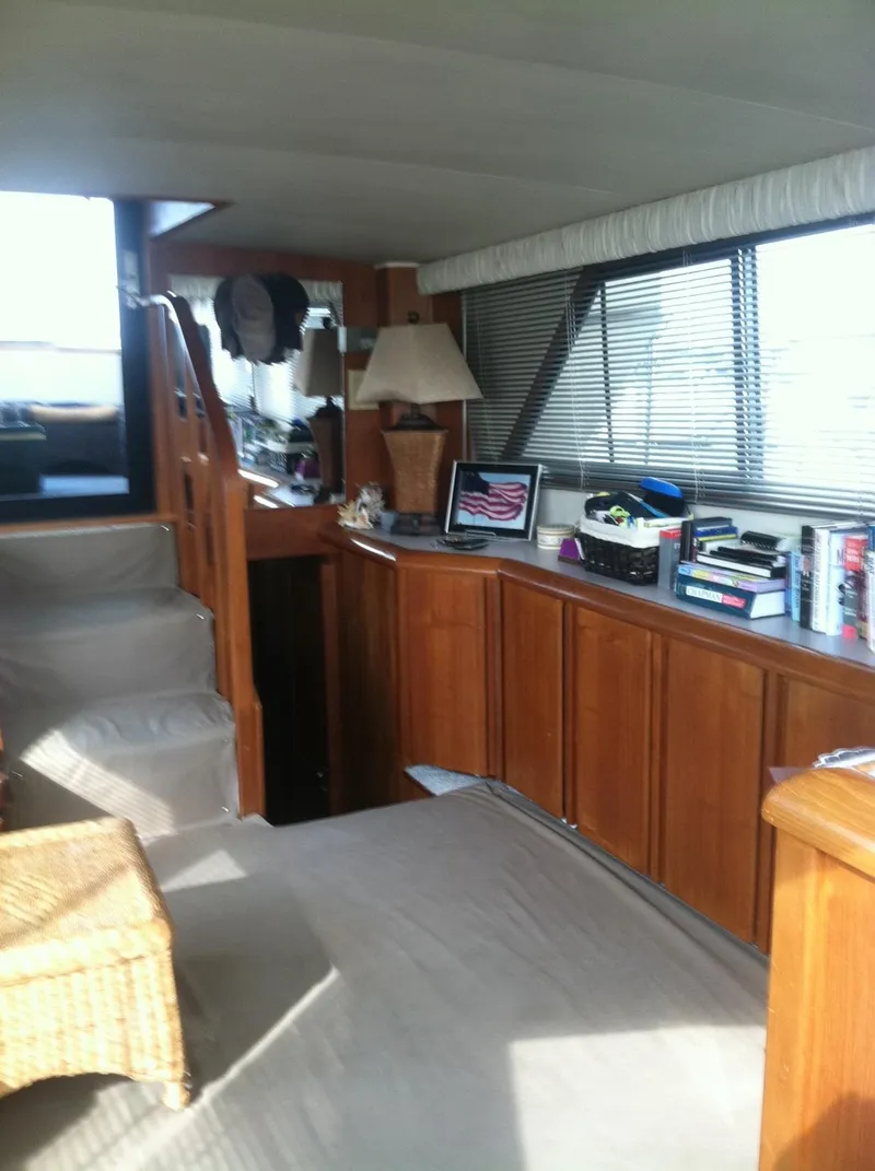Slide: The Image of Interior of 1989 Californian 48 Motor Yacht with wooden cabinetry and cozy seating area. - 14