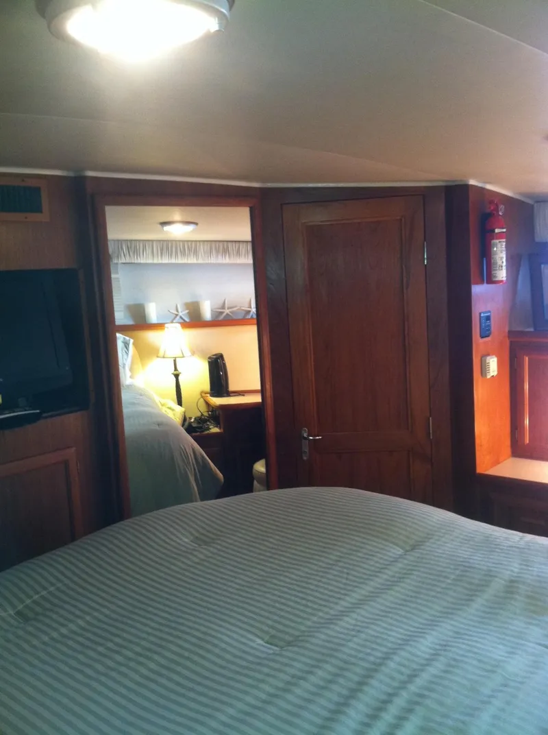 Slide: The Image of Interior of 1989 Californian 48 Motor Yacht with cozy bedroom and wooden furnishings. - 15