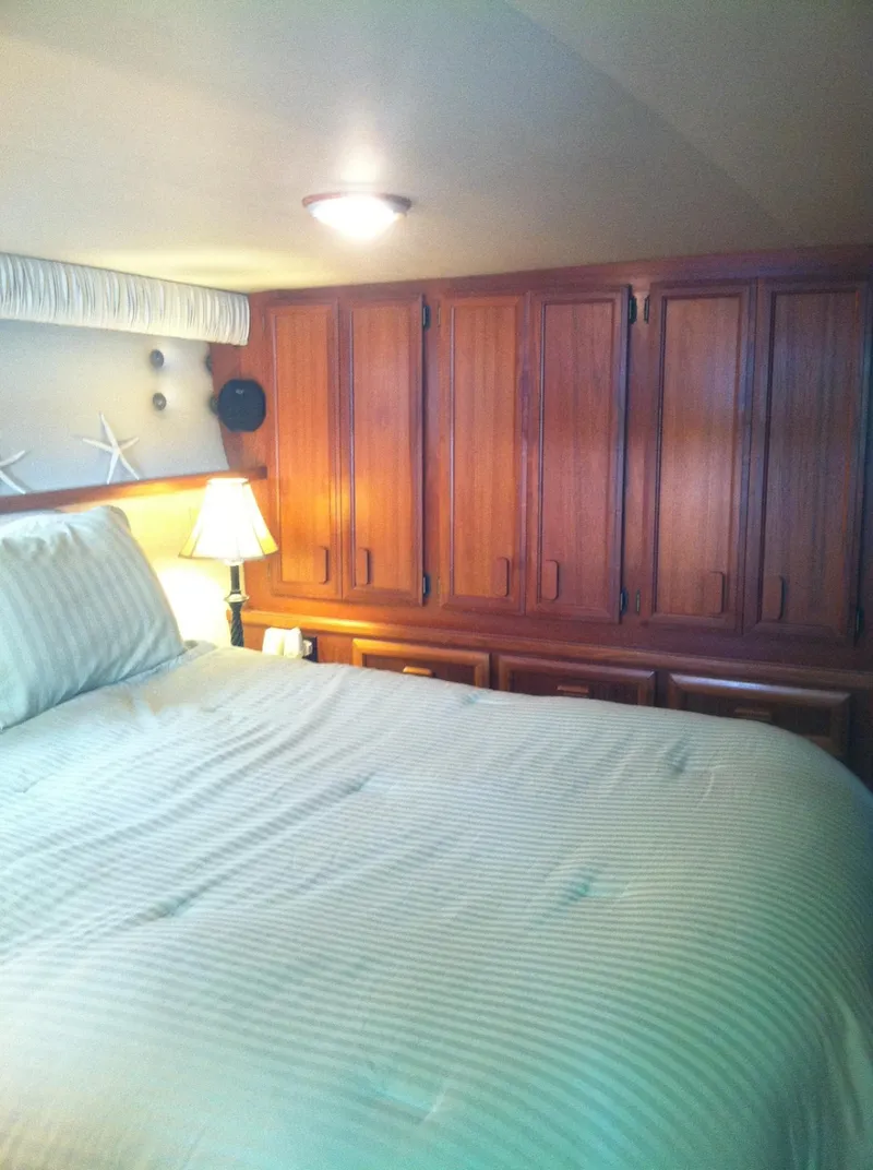 Slide: The Image of Cozy bedroom interior of 1989 Californian 48 Motor Yacht with wooden cabinets and soft lighting. - 18
