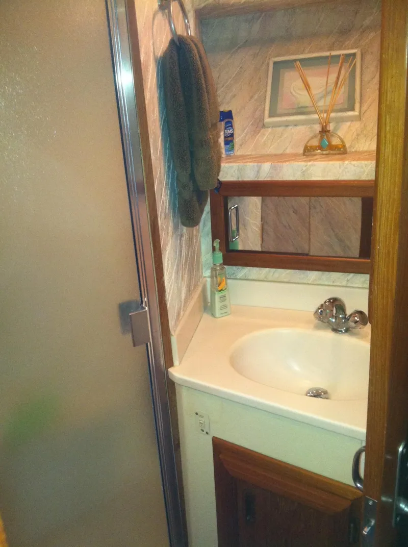 Slide: The Image of 1989 Californian 48 Motor Yacht bathroom with sink, mirror, and toiletries. - 28
