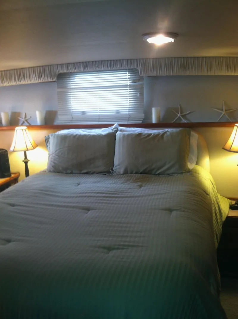 Slide: The Image of Cozy bedroom interior of 1989 Californian 48 Motor Yacht with soft lighting and nautical decor. - 37