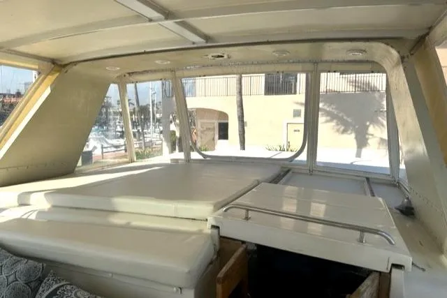 Slide: The Image of Interior view of 1989 Californian 48 Motor Yacht with cushioned seating and large windows. - 48