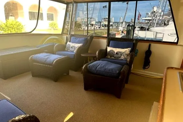 Slide: The Image of Interior of 1989 Californian 48 Motor Yacht with blue cushioned seating and marina view. - 9