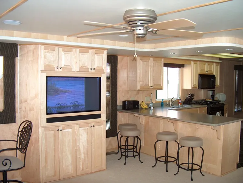 Slide: The Image of 2005 Stardust Cruisers Multi Owner Houseboat kitchen with modern amenities and wooden cabinetry. - 3