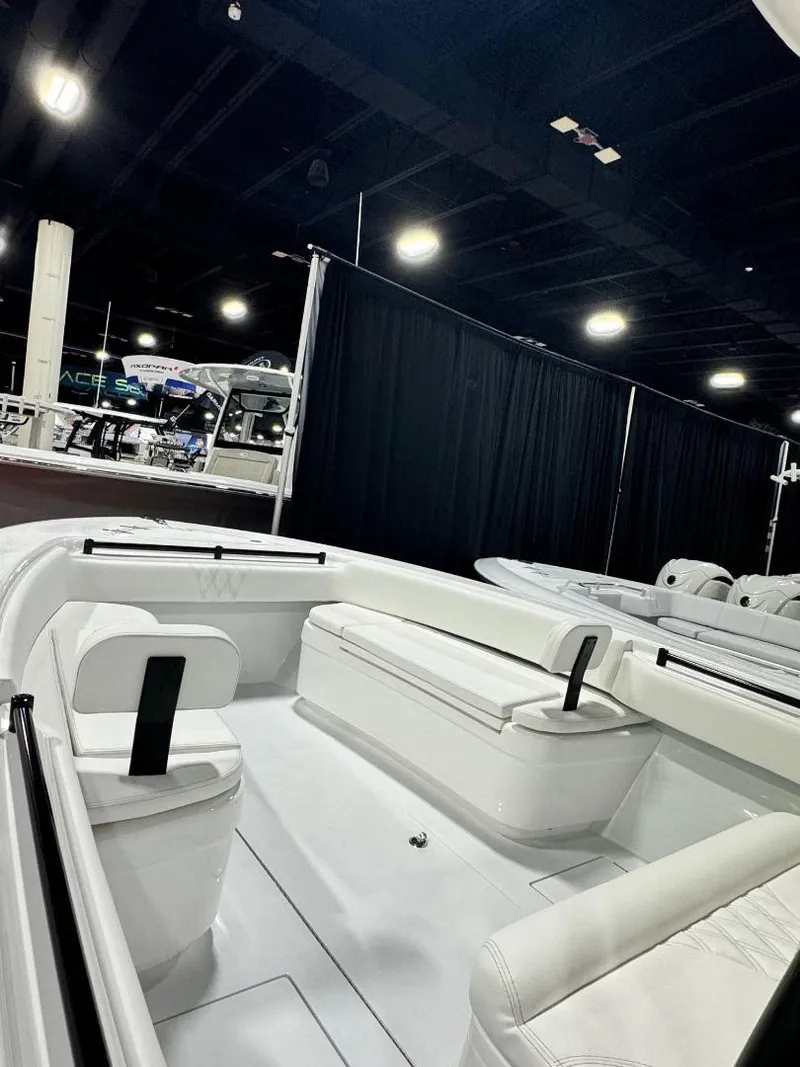 Slide: The Image of 2025 Contender 28S boat interior at a showroom, featuring sleek white seating and modern design. - 11