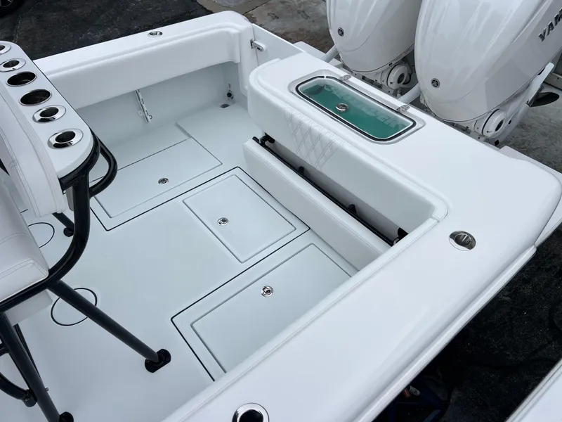 Slide: The Image of 2025 Contender 28S boat deck with storage compartments and dual outboard engines. - 14