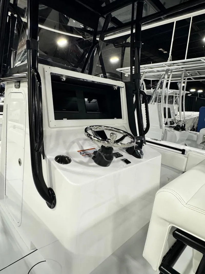 Slide: The Image of 2025 Contender 28S boat console with steering wheel and controls, showcased indoors. - 7