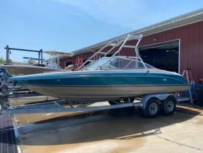 Slide: The Image of 1996 Maxum 2100SS Ski boat on a trailer outside a red building. - 8