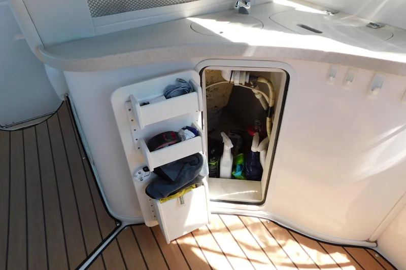 Slide: The Image of Storage compartment on 2002 Rinker Fiesta Vee 310 boat, containing cleaning supplies and towels. - 18