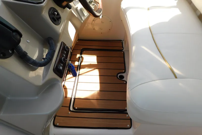 Slide: The Image of 2002 Rinker Fiesta Vee 310 interior with wood flooring and white seating. - 24