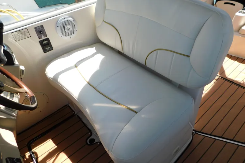 Slide: The Image of 2002 Rinker Fiesta Vee 310 boat interior with white cushioned seating and wood flooring. - 25