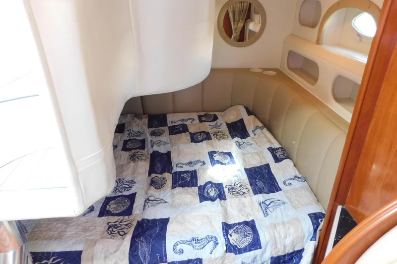 Slide: The Image of 2002 Rinker Fiesta Vee 310 cabin with nautical-themed bedding and cozy interior design. - 32