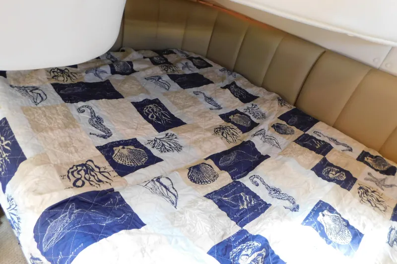 Slide: The Image of Interior cabin of 2002 Rinker Fiesta Vee 310 with nautical-themed bedding. - 33